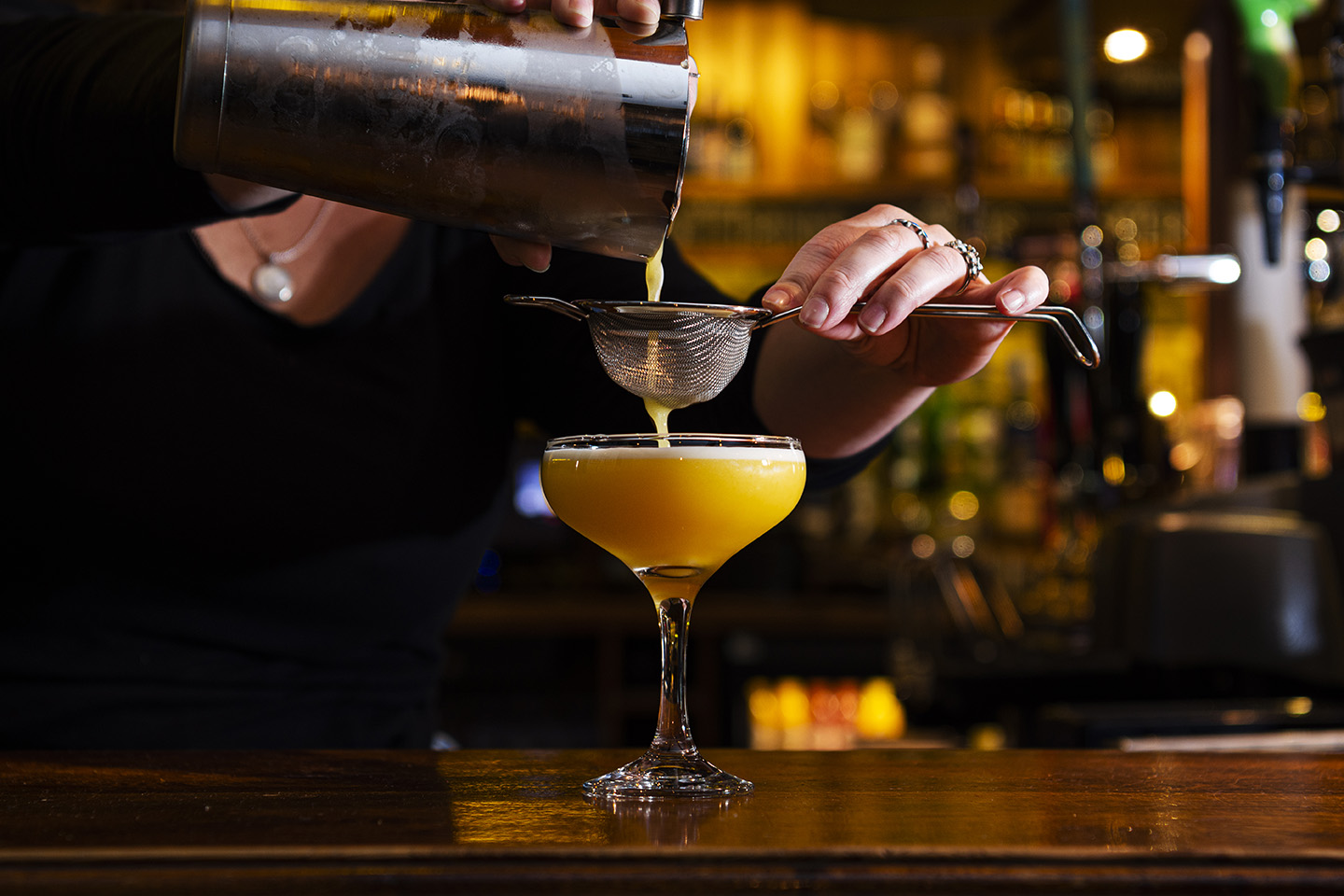 Image shows a passion fruit cocktail being poured at the bar in the Polgooth Inn pub
