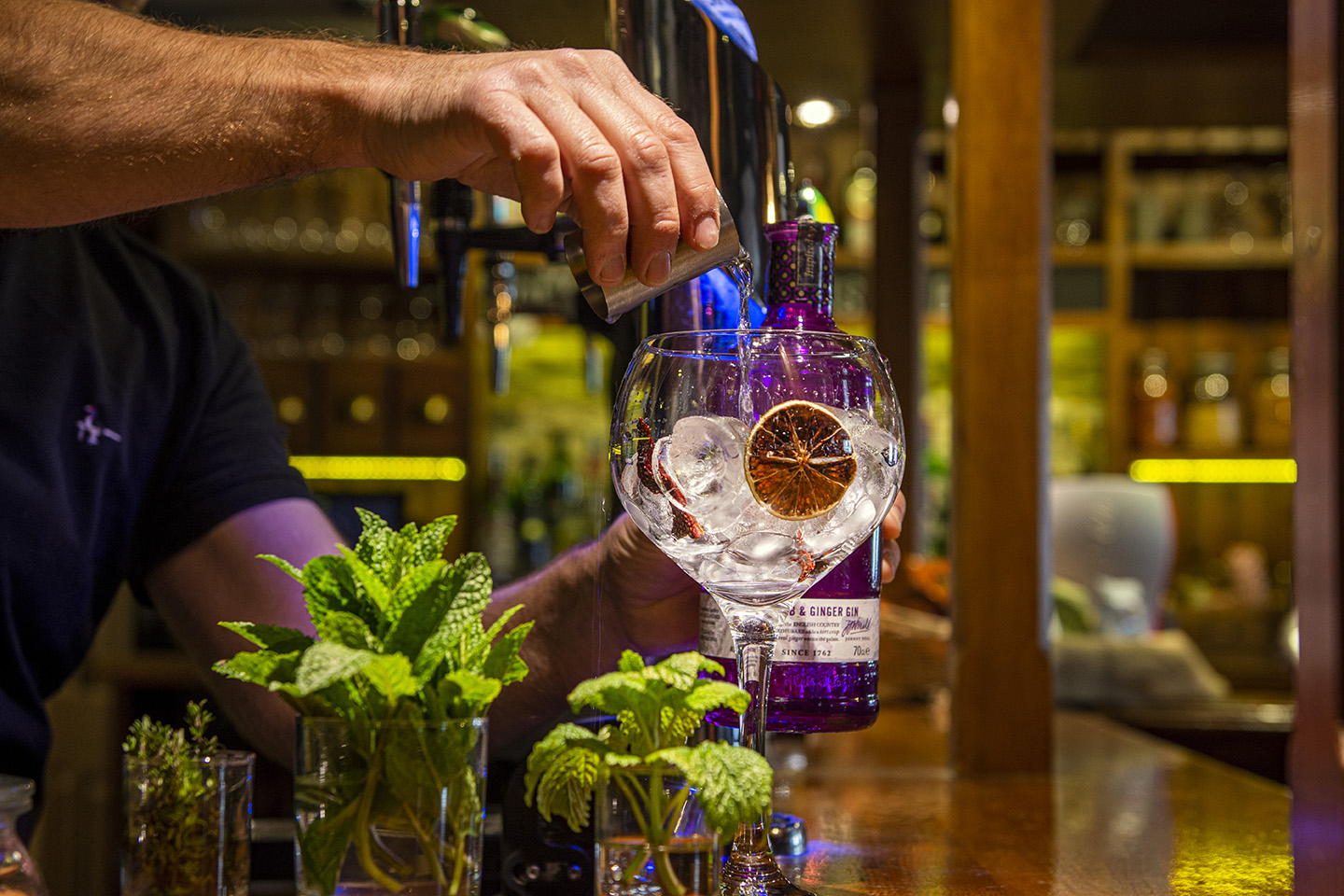 image shows a a large gin and tonic being poured at the bar
