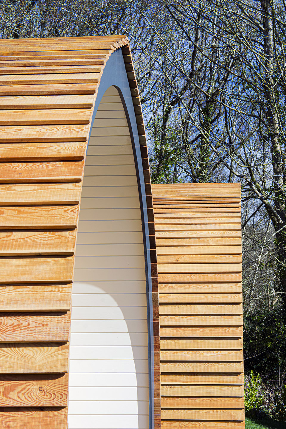 Image shows the roofline of the garden pods holiday accommodation at the Polgooth Inn with trees in the background