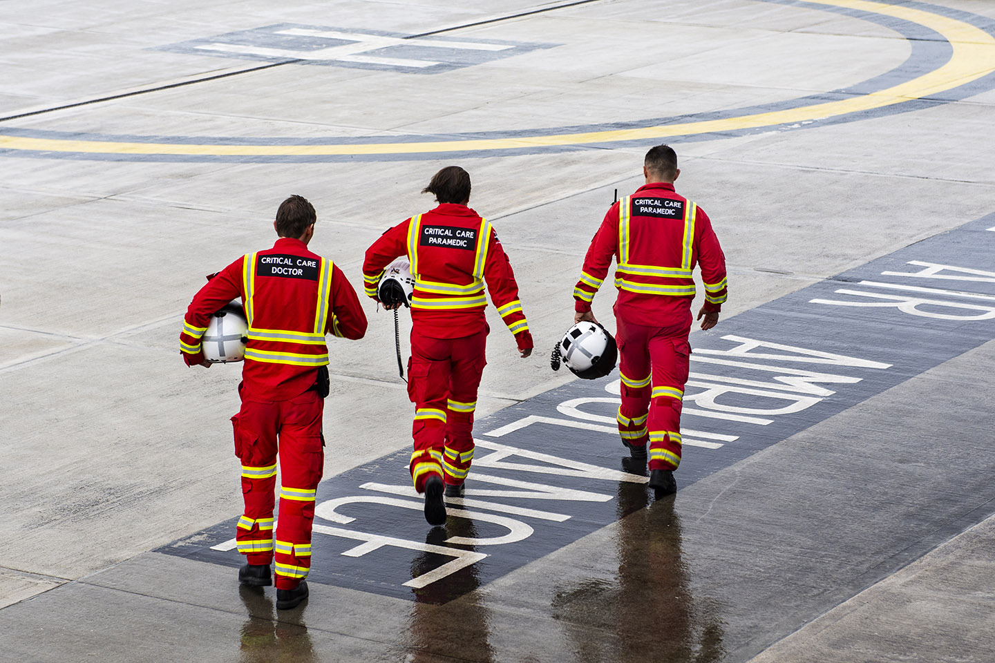 Three Cornwall Air Ambulance paramedics walking across the helicopter landing pad