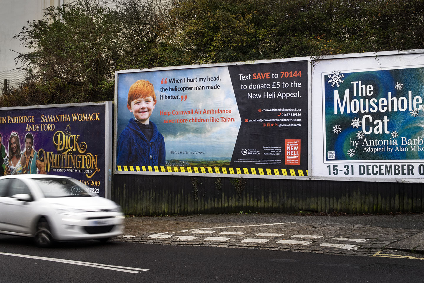 Large billboard advertisement featuring a photo of a little boy whose life was saved by Cornwall Air Ambulance