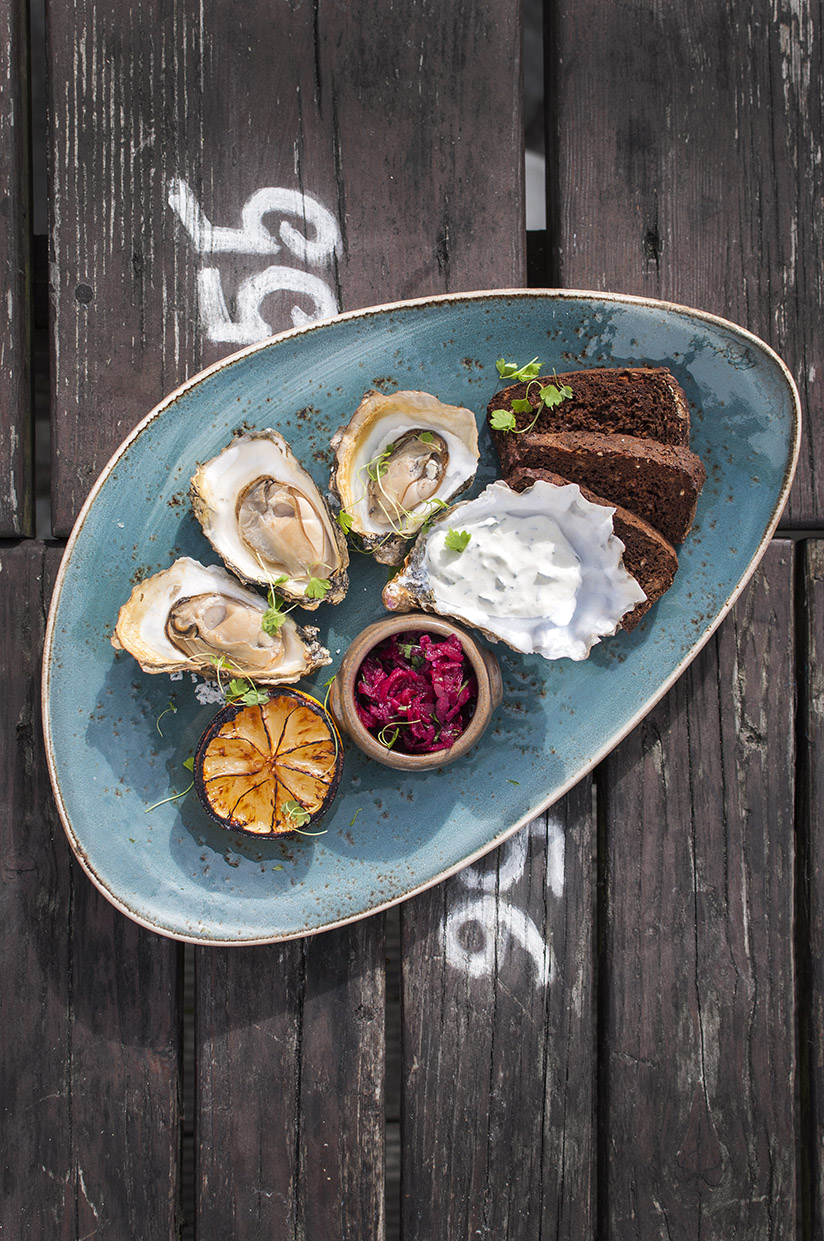 Large turquoise plate with smoked oysters with pickled beetroot and creme fraiche