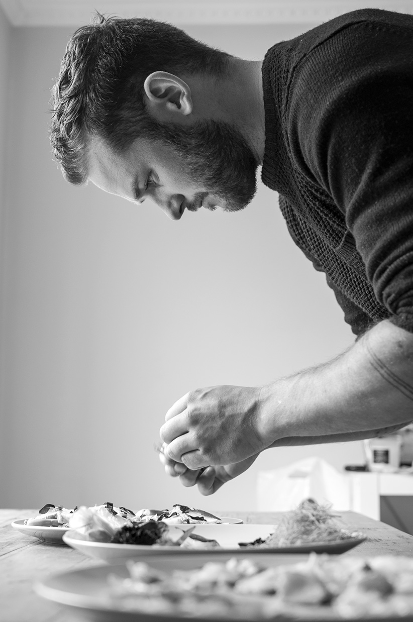 Black and white portrait of chef Rick Toogood preparing lobster carpaccio 