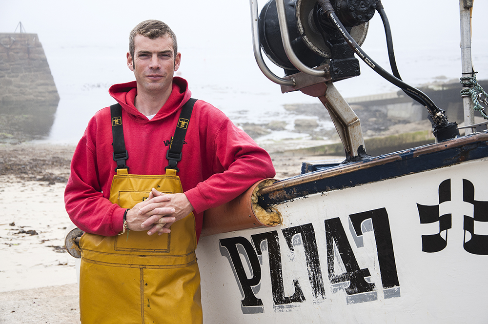 Portrait of fisherman Ben George by his boat at Sennen in Cornwall.