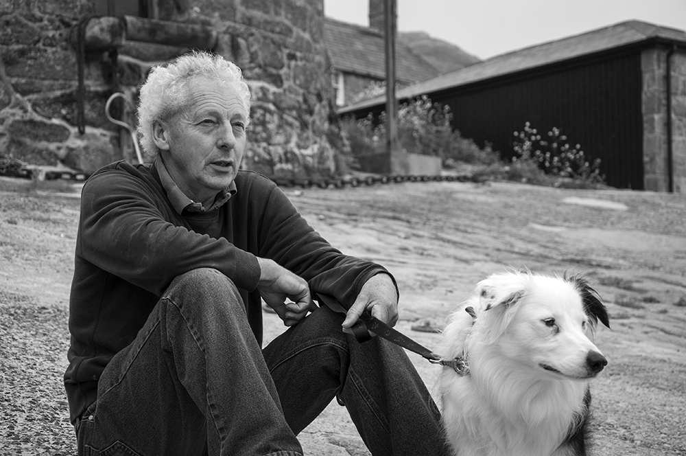 Portrait of Sennen harbourmaster and lifeboatman, Terry George with his dog