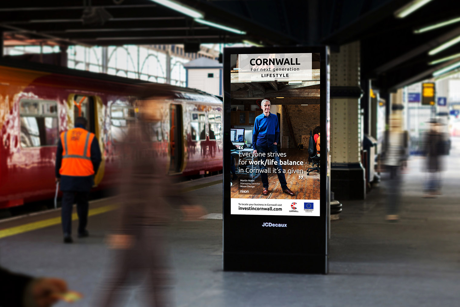 A JC Decaux digital billboard at a busy London station with a portrait of Martin Nixon of Nixon Design on it