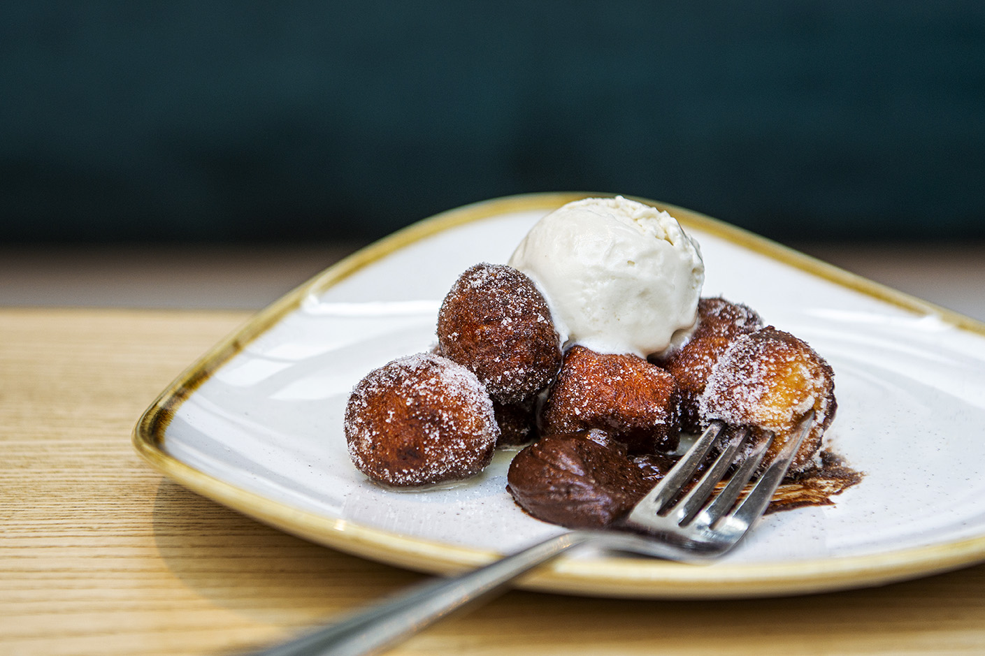 Close up of a plate of ricotta doughnuts with a scoop of ice cream