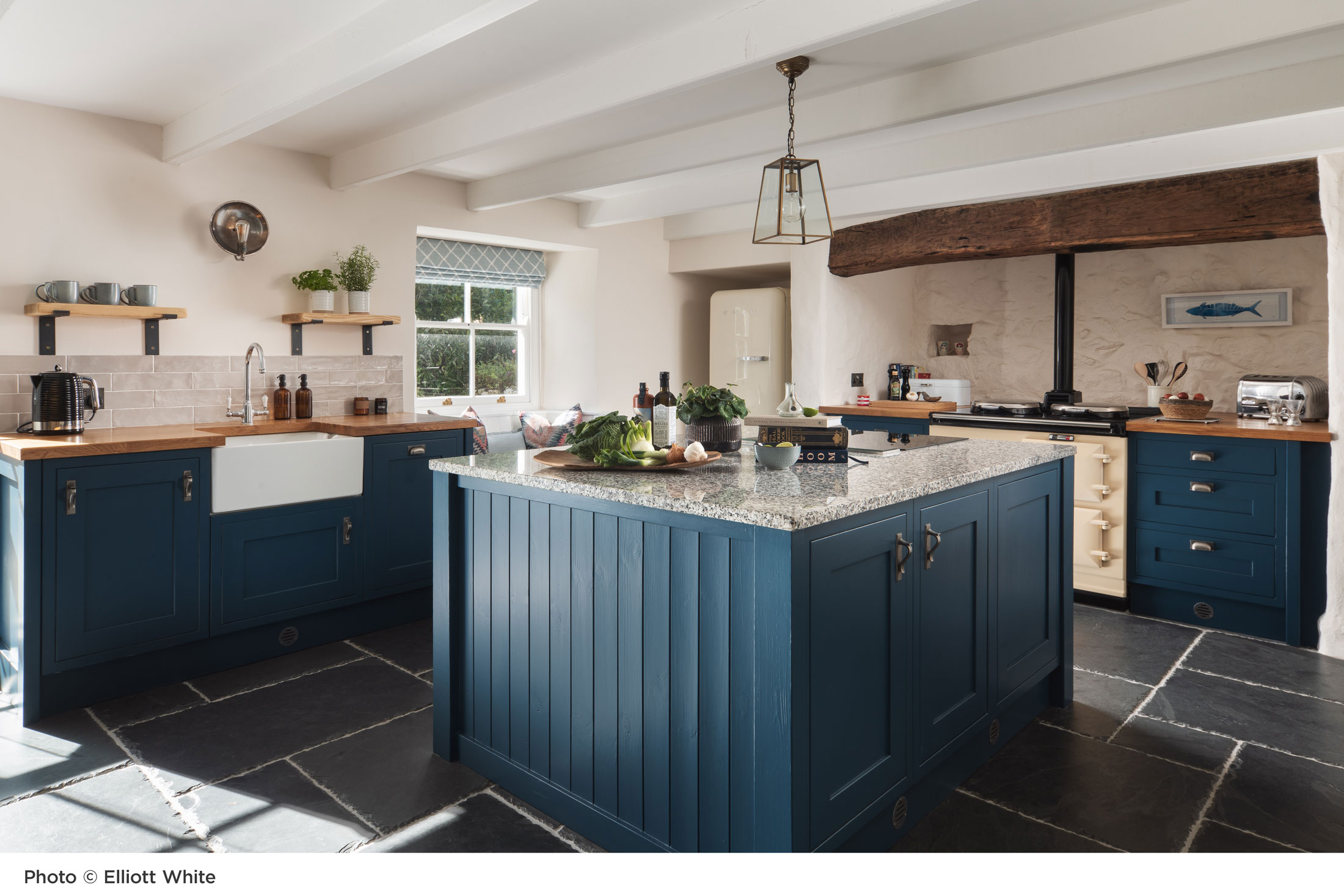 photo of a bespoke kitchen design by Nicola O'Mara with dark blue cabinetry and slate tiled floor