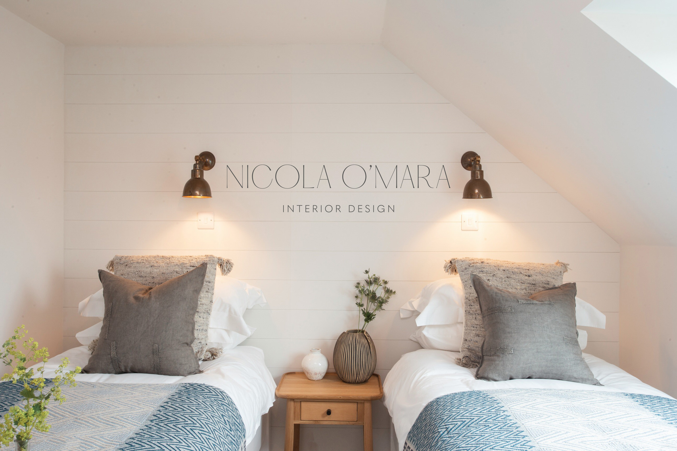 Photo of a beautifully designed bedroom with Nicola O'Mara logo superimposed on the wall