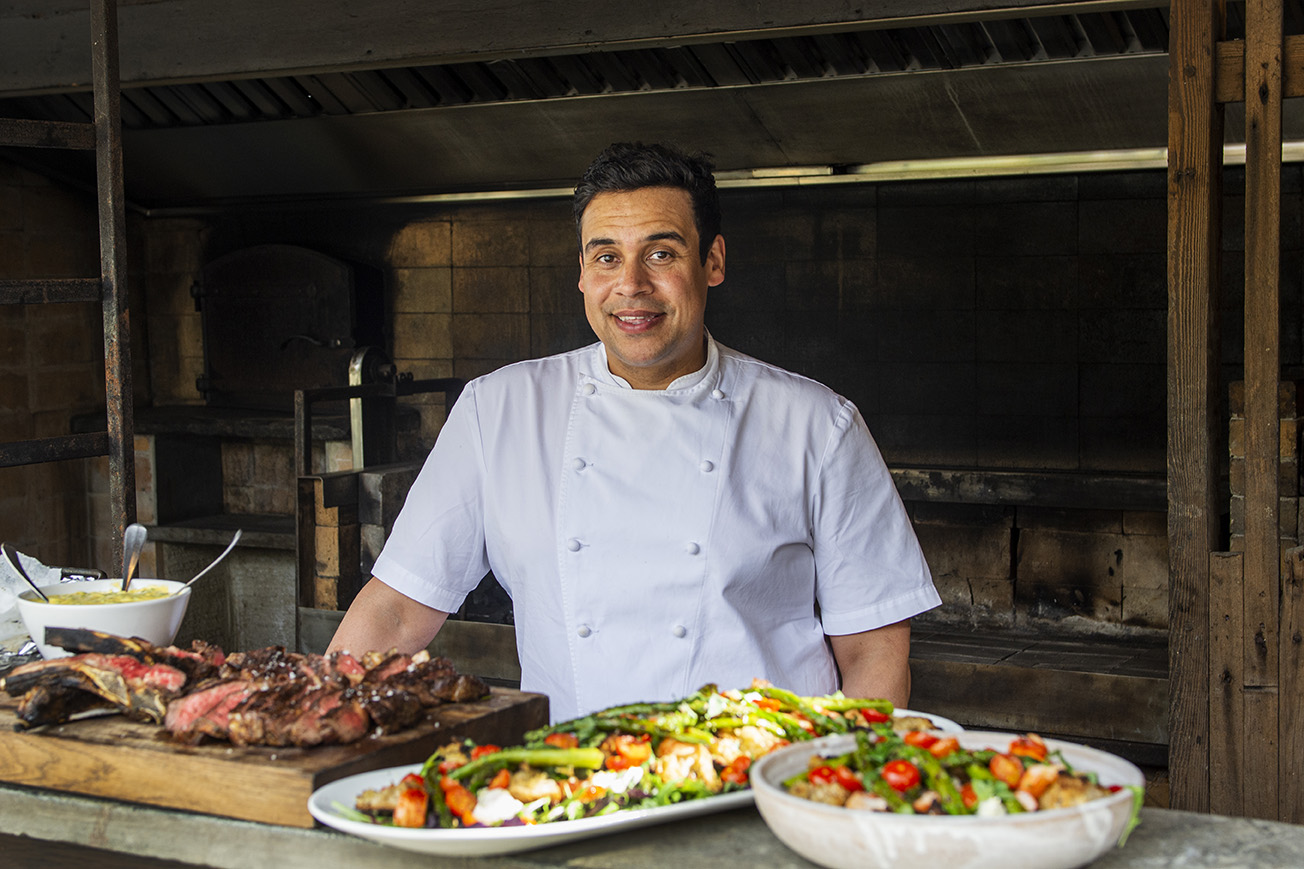 A portrait of chef Paul Ainsworth at Nancarrow Farm with prepared dishes of food in the foreground